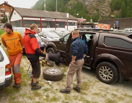 Vlak jsme přežili, camp večer našli a ráno jen koukali - Pati a Mati mění zcela prázdné levé přední pneu.  